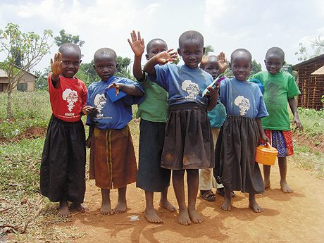 Group of school children waving at the camera Group of school children waving at the camera